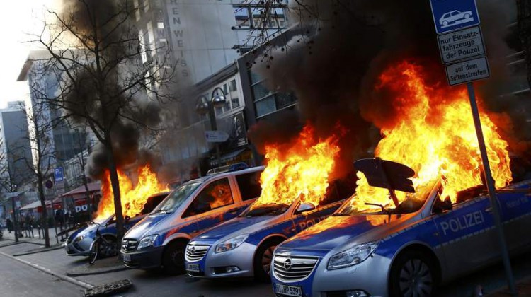 Four German police cars set on fire by anti-capitalist protesters burn near the new ECB headquarters in downtown Frankfurt